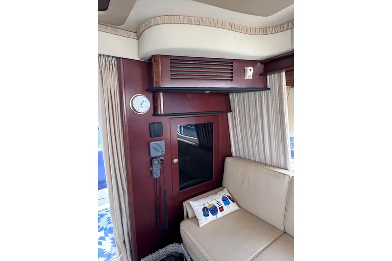 Slide: The Image of Interior of 2006 Sea Ray 44 Sedan Bridge with clock, radio, and beige seating. - 26