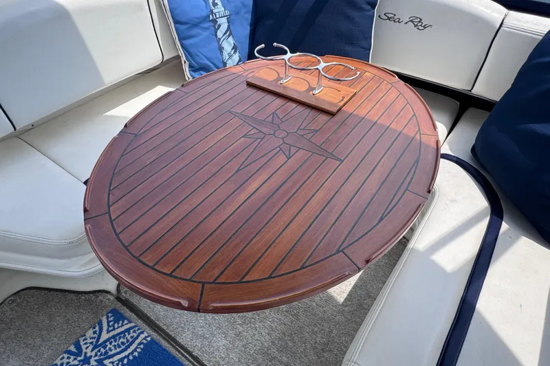 Slide: The Image of Luxurious wooden table on 2006 Sea Ray 44 Sedan Bridge yacht, featuring cup holders and cushioned seating. - 35