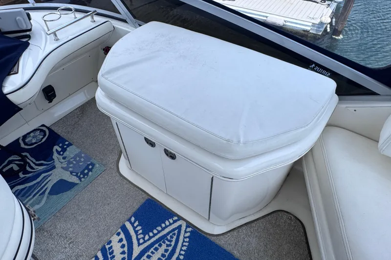 Slide: The Image of Interior of 2006 Sea Ray 44 Sedan Bridge with white seating and nautical-themed rugs. - 36
