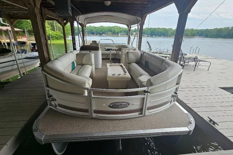 Slide: The Image of 2006 JC NepToon 23 TT pontoon boat docked, featuring spacious seating and scenic lake view. - 4