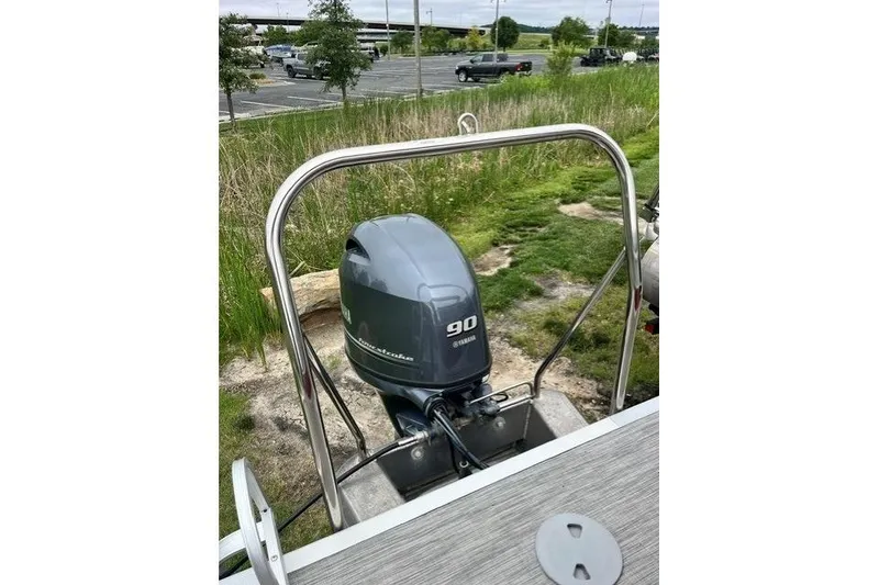Slide: The Image of 2021 Bennington 205SL boat with Yamaha 90 outboard motor, parked near grassy area. - 11