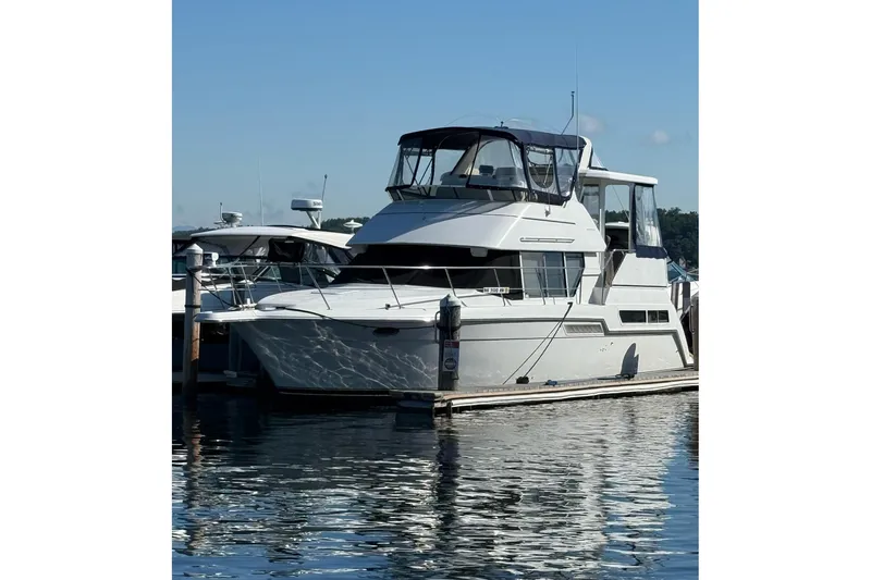 The Image of 1997 Carver 355 Aft Cabin Motor Yacht docked at marina under clear blue sky. - 1