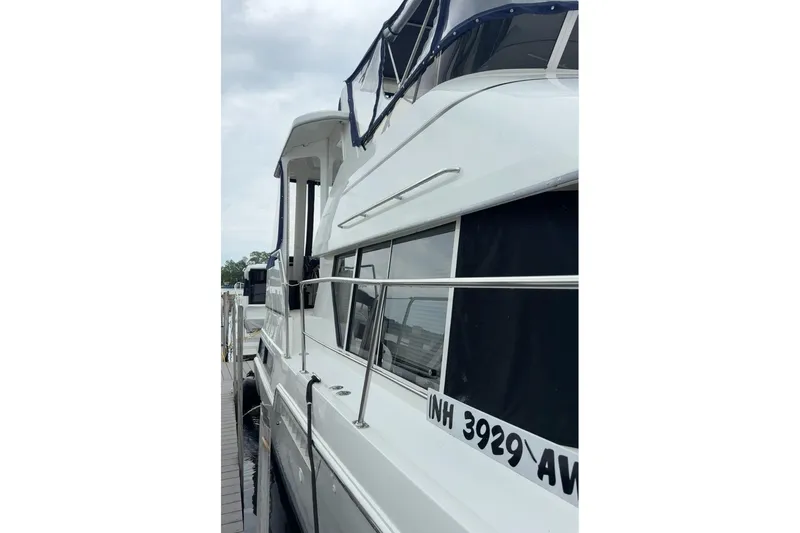 Slide: The Image of 1997 Carver 355 Aft Cabin Motor Yacht docked, showcasing sleek design and spacious cabin. - 5