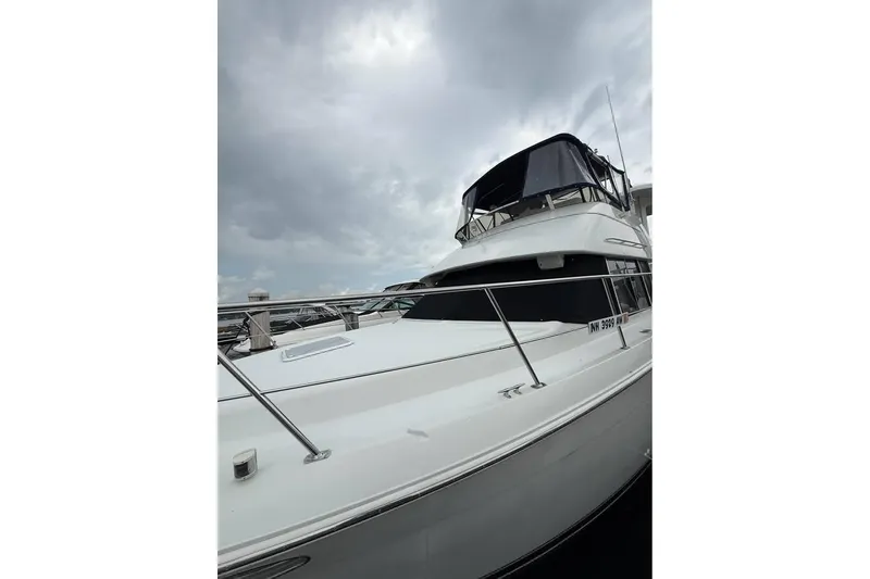 Slide: The Image of 1997 Carver 355 Aft Cabin Motor Yacht docked under cloudy skies. - 4