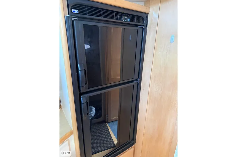 Slide: The Image of Refrigerator inside 1997 Carver 355 Aft Cabin Motor Yacht, featuring dual black doors. - 21