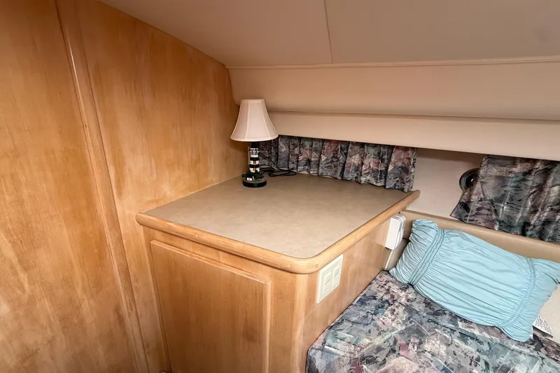 Slide: The Image of 1997 Carver 355 Aft Cabin Motor Yacht interior with wooden cabinetry and cozy bedding. - 20