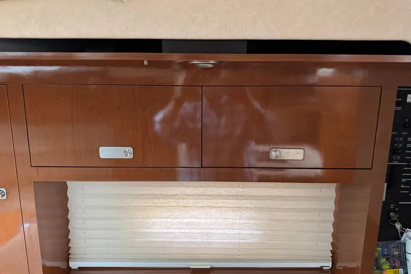 Slide: The Image of Interior cabinetry of 2010 Sea Ray Sundancer 310 with wooden finish and window blinds. - 27