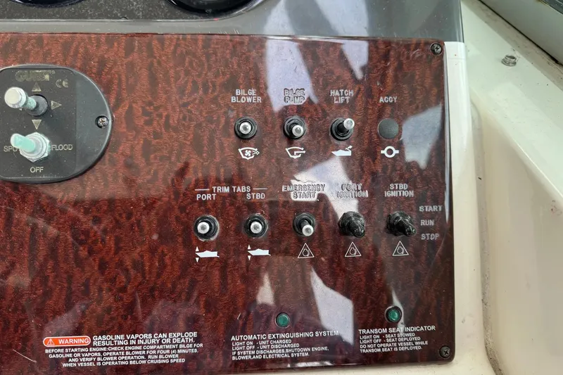 Slide: The Image of Control panel of a 2010 Sea Ray Sundancer 310 boat with various switches and warnings. - 38