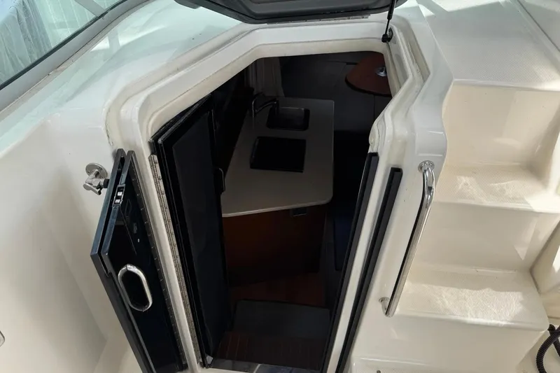 Slide: The Image of Entrance to cabin of 2010 Sea Ray Sundancer 310 yacht, showing interior stairs and kitchenette. - 22