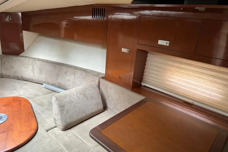Slide: The Image of Interior of 2010 Sea Ray Sundancer 310, featuring cozy seating and elegant wood cabinetry. - 24