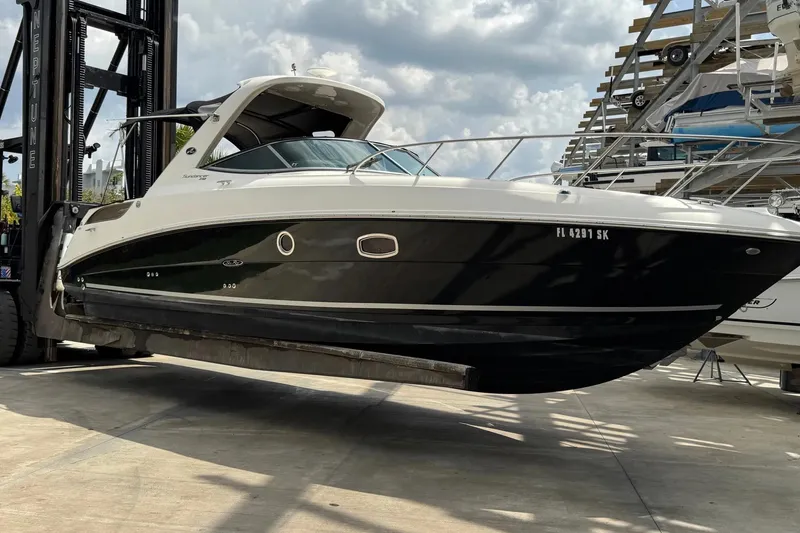 Slide: The Image of 2010 Sea Ray Sundancer 310 boat lifted by forklift in marina storage. - 30