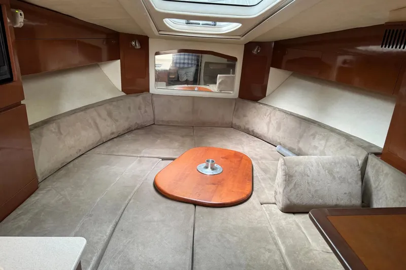 Slide: The Image of Interior of 2010 Sea Ray Sundancer 310, featuring plush seating and wooden table. - 23