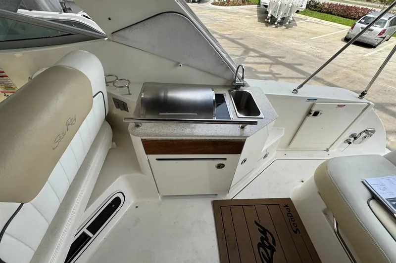 Slide: The Image of 2010 Sea Ray Sundancer 310 boat interior with kitchenette and seating area. - 18
