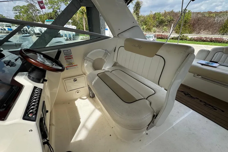 Slide: The Image of Interior of a 2010 Sea Ray Sundancer 310 boat with white seating and steering wheel. - 17