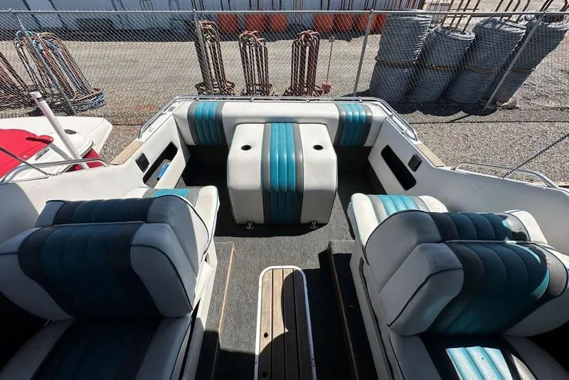 Slide: The Image of 1992 Reinell 192 RM boat interior with blue and white seating, docked outdoors. - 8