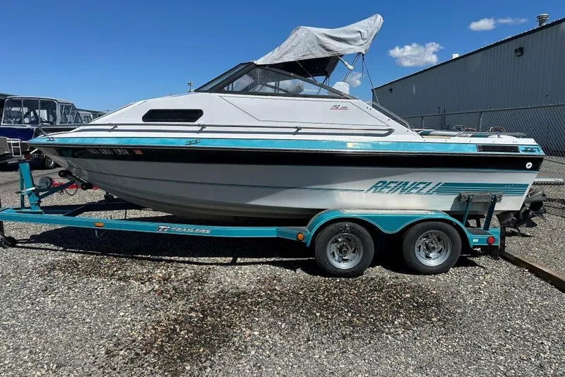 Slide: The Image of 1992 Reinell 192 RM boat on trailer, parked outdoors under clear blue sky. - 3