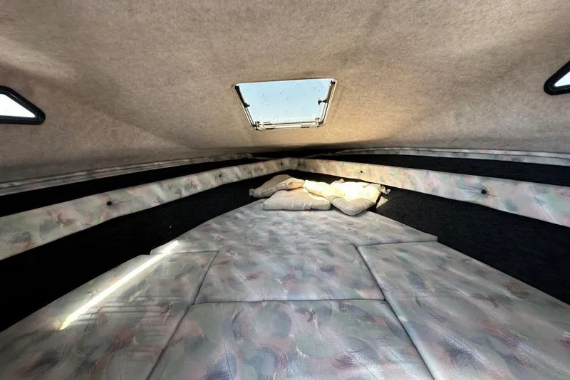 Slide: The Image of Interior cabin of a 1992 Reinell 192 RM boat with cushioned seating and overhead hatch. - 7