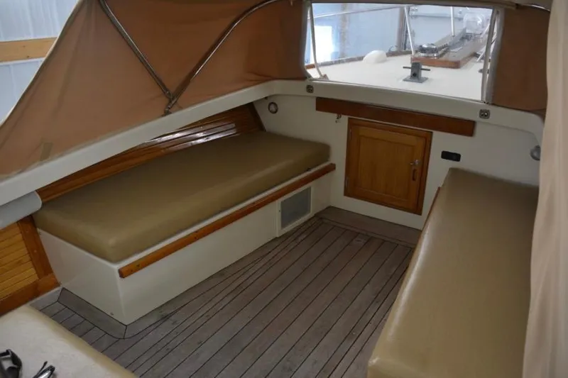 Slide: The Image of Interior of 1988 Bunker and Ellis 24 Open boat with cushioned seating and wooden accents. - 29