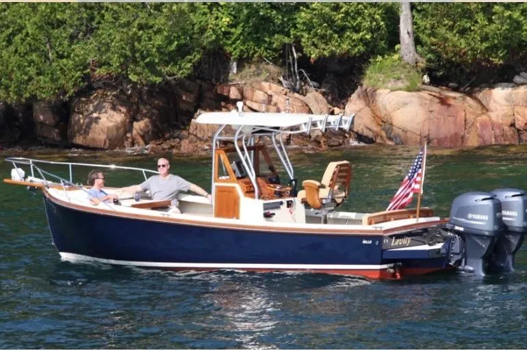 Slide: The Image of 1988 Bunker and Ellis 24 Open boat cruising near rocky shoreline with two passengers. - 7