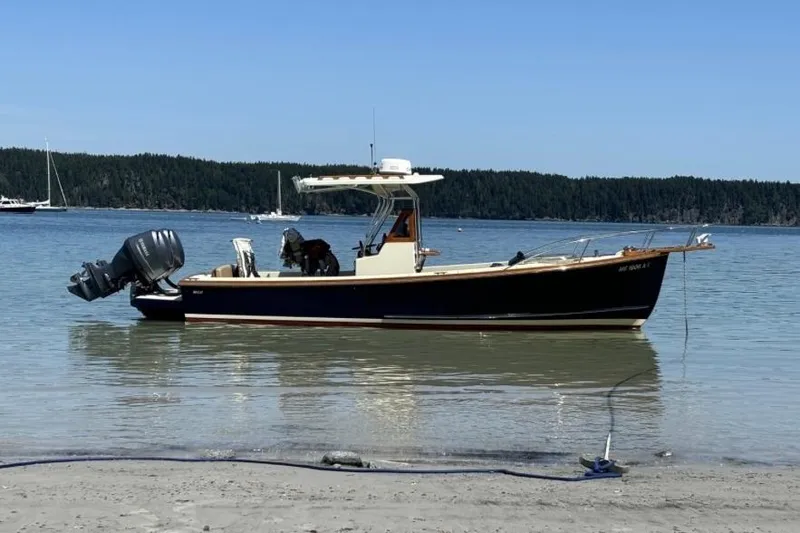 The Image of 1988 Bunker and Ellis 24 Open boat anchored on a calm lake with forested shoreline. - 0