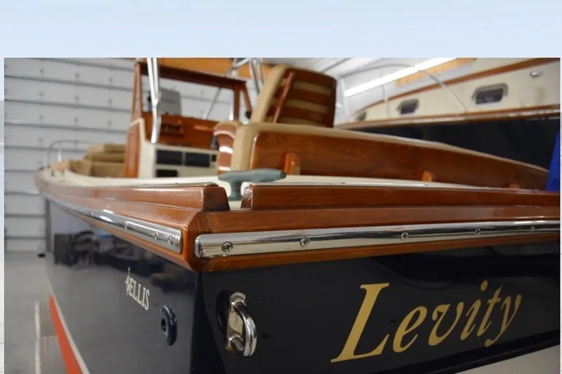 Slide: The Image of 1988 Bunker and Ellis 24 Open boat named "Levity" with wooden details in a garage. - 19
