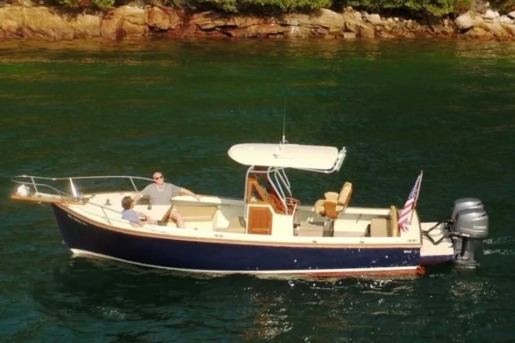 Slide: The Image of 1988 Bunker and Ellis 24 Open boat on water, two people onboard, American flag displayed. - 3