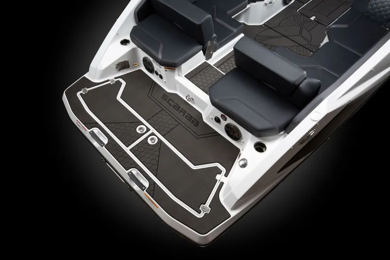 Slide: The Image of The image shows the rear of a Scarab 255 LX boat with black seating and flooring. - 12