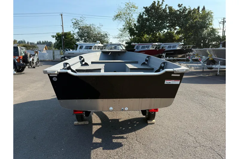 Slide: The Image of 2025 Smoker Craft Big Fisherman 14 boat in a parking lot, rear view. - 2
