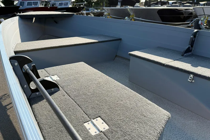 Slide: The Image of 2025 Smoker Craft Big Fisherman 14 boat interior with carpeted seating and storage compartments. - 6