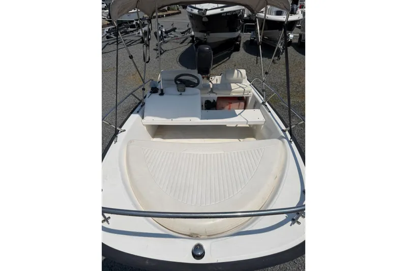 Slide: The Image of 2003 Boston Whaler 130 Super Sport boat interior with steering wheel and seating area. - 3