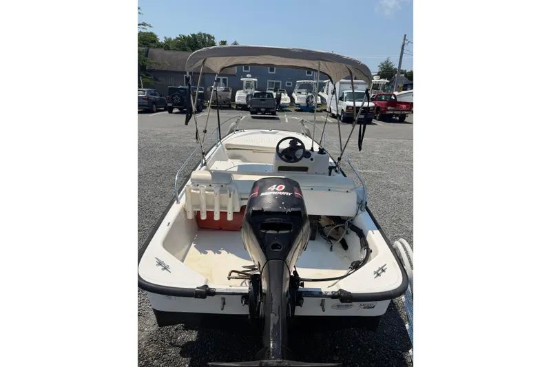 Slide: The Image of 2003 Boston Whaler 130 Super Sport boat with canopy and Mercury 40 HP engine. - 2