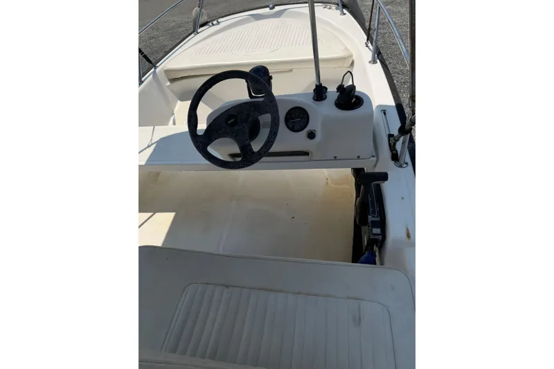 Slide: The Image of 2003 Boston Whaler 130 Super Sport boat interior with steering wheel and controls. - 5