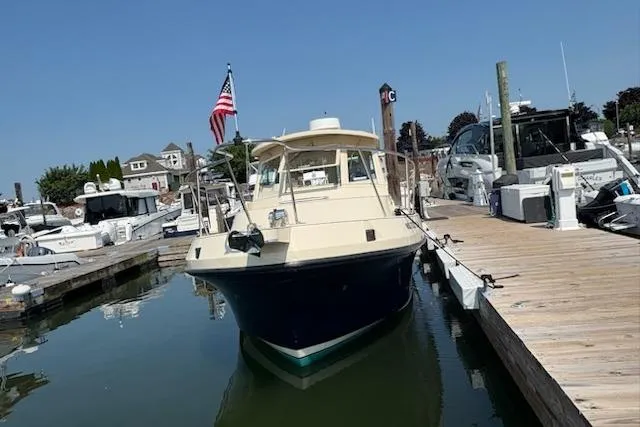 Slide: The Image of 2003 Albin 28 Tournament Express docked at a marina with American flag. - 10