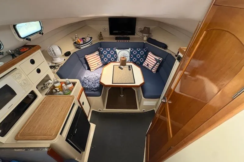 Slide: The Image of Interior of 2003 Albin 28 Tournament Express with cozy seating and compact kitchen area. - 23