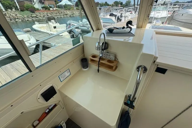 Slide: The Image of 2003 Albin 28 Tournament Express boat interior with sink and marina view. - 21