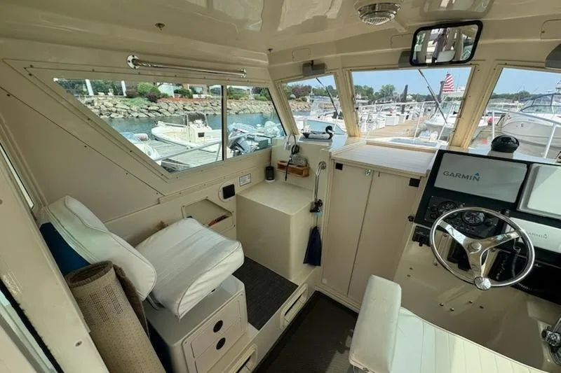 Slide: The Image of Interior of a 2003 Albin 28 Tournament Express boat with steering wheel and navigation equipment. - 24