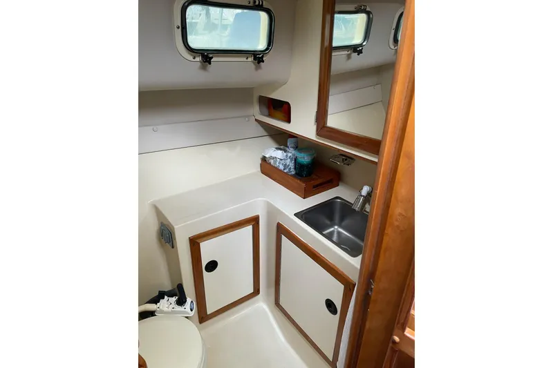 Slide: The Image of 2003 Albin 28 Tournament Express boat interior with sink, storage, and window. - 15