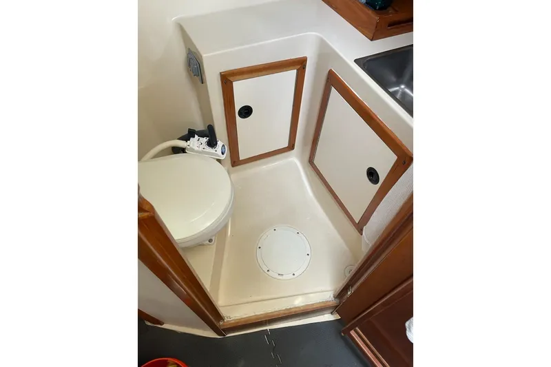Slide: The Image of 2003 Albin 28 Tournament Express boat bathroom with toilet and storage cabinets. - 16