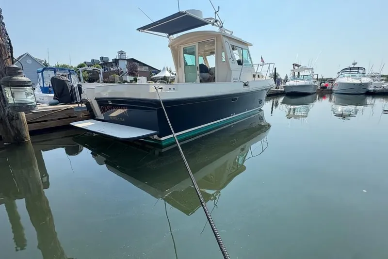 Slide: The Image of 2003 Albin 28 Tournament Express boat docked in a marina on a sunny day. - 2