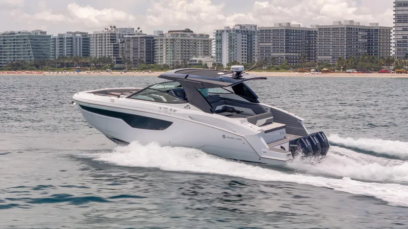 Slide: The Image of 2021 Cruisers Yachts 38 GLS speeding on water near city skyline. - 12