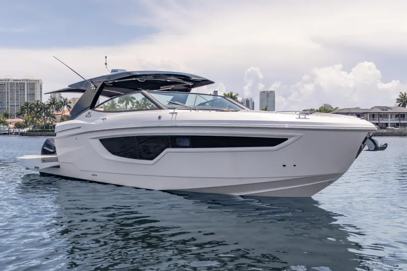 Slide: The Image of 2021 Cruisers Yachts 38 GLS luxury boat on calm water, cityscape background. - 1