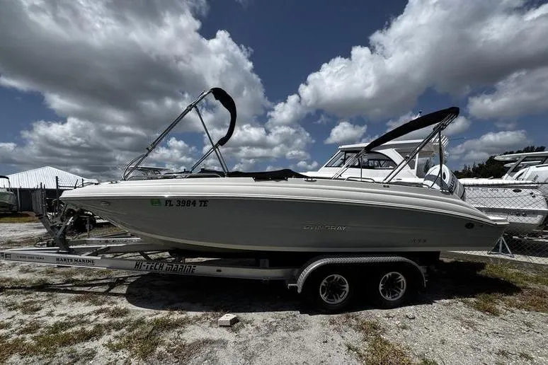 The Image of 2022 Stingray 212 SC boat on trailer under cloudy sky. - 1