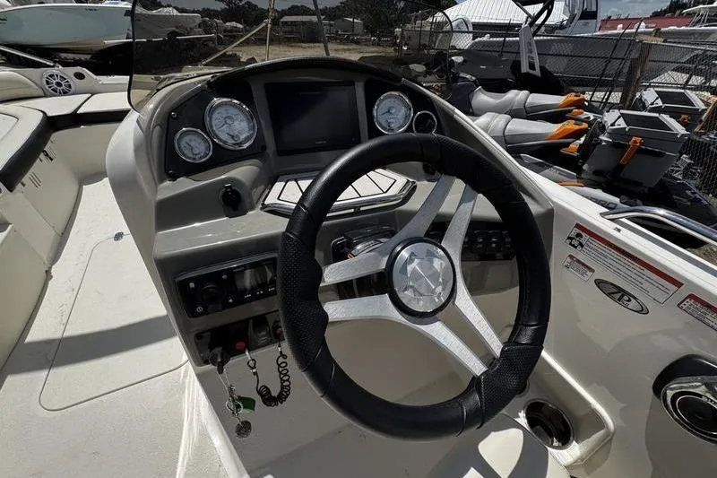 Slide: The Image of 2022 Stingray 212 SC boat dashboard with steering wheel and gauges. - 21