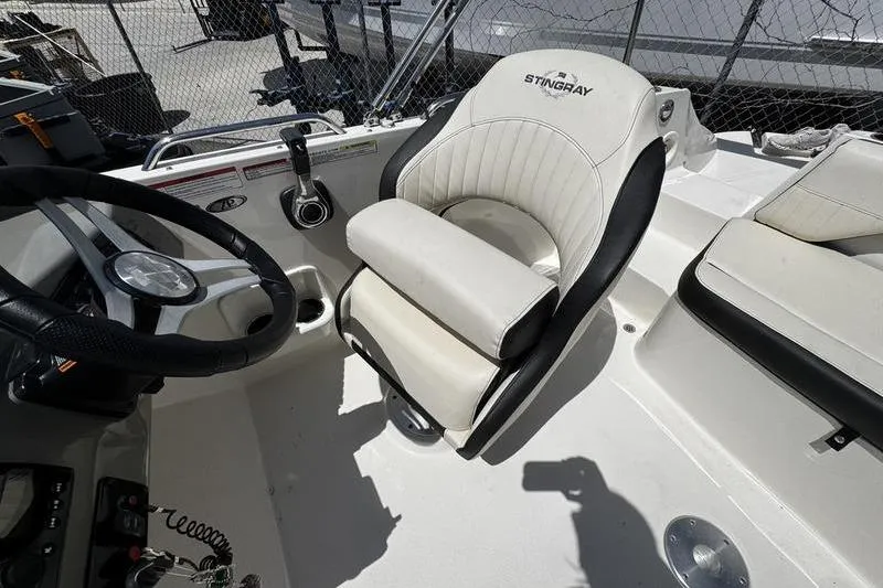 Slide: The Image of 2022 Stingray 212 SC boat interior with steering wheel and comfortable seating. - 22