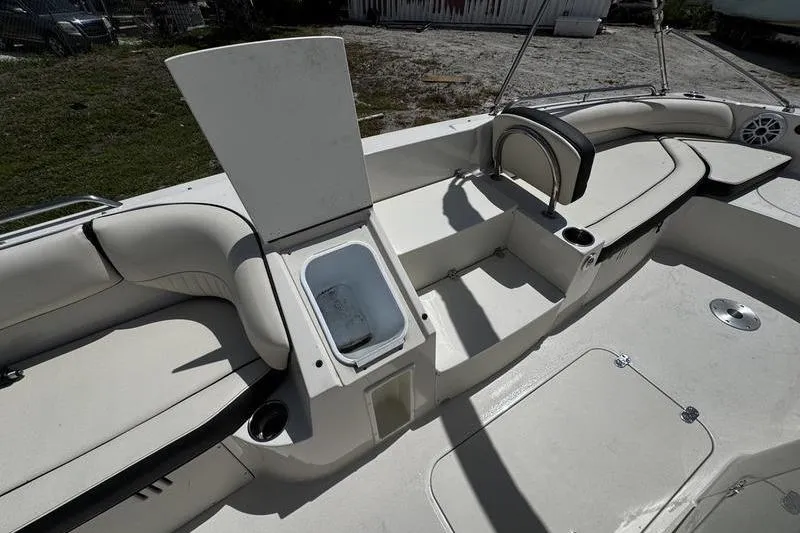 Slide: The Image of 2022 Stingray 212 SC boat interior with open storage compartment and cushioned seating. - 13