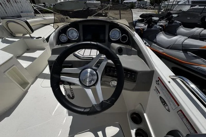 Slide: The Image of 2022 Stingray 212 SC boat dashboard with steering wheel and control panel. - 20