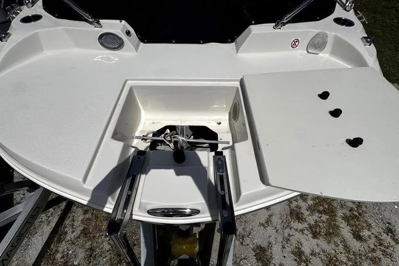 Slide: The Image of 2022 Stingray 212 SC boat deck with storage compartment and ladder. - 5