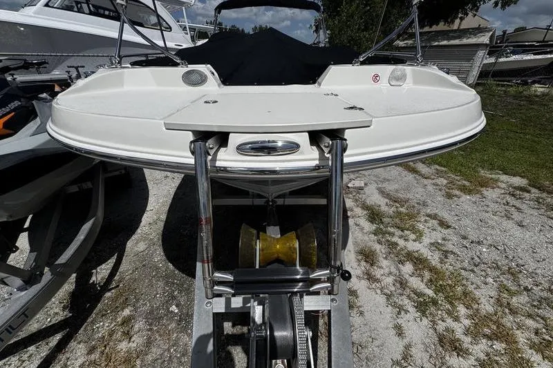 Slide: The Image of 2022 Stingray 212 SC boat on trailer, front view, outdoors. - 4