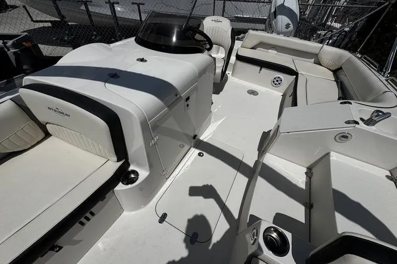 Slide: The Image of 2022 Stingray 212 SC boat interior with white seating and steering console. - 11