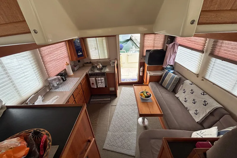 Slide: The Image of Interior of a 2004 Nordic Tug 37, featuring a cozy living area and kitchen. - 22